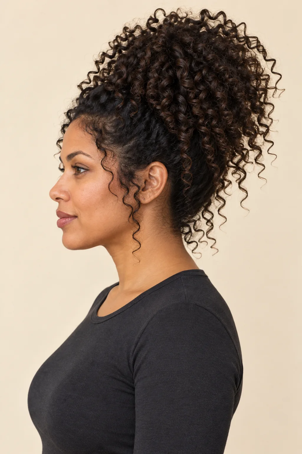 Side view of a loose high curly pineapple with visible curl ends.
